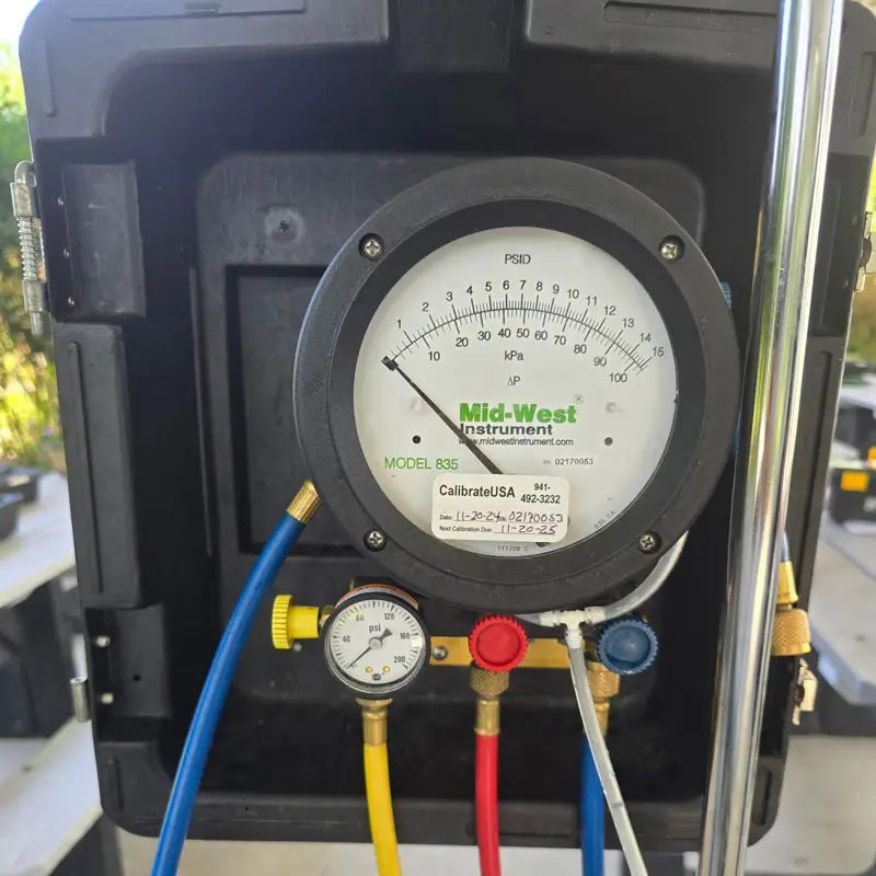 Differential pressure gauge and hoses connected to a Mid-West Instrument Model 835 used for certified backflow testing in Charlotte County.